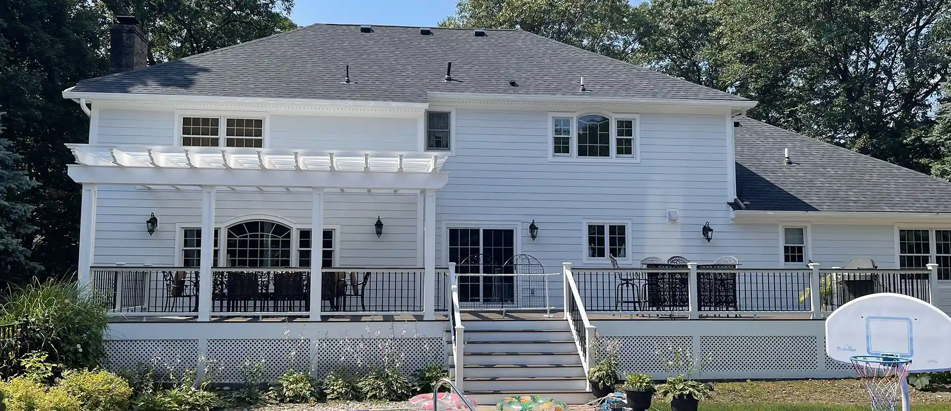 photo of a custom deck with a pergola and lattice deck skirting