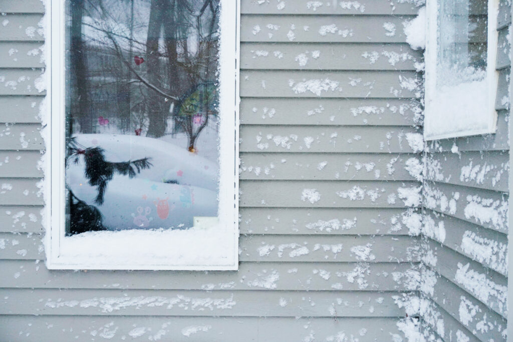 Siding of a house covered in snow during the winter