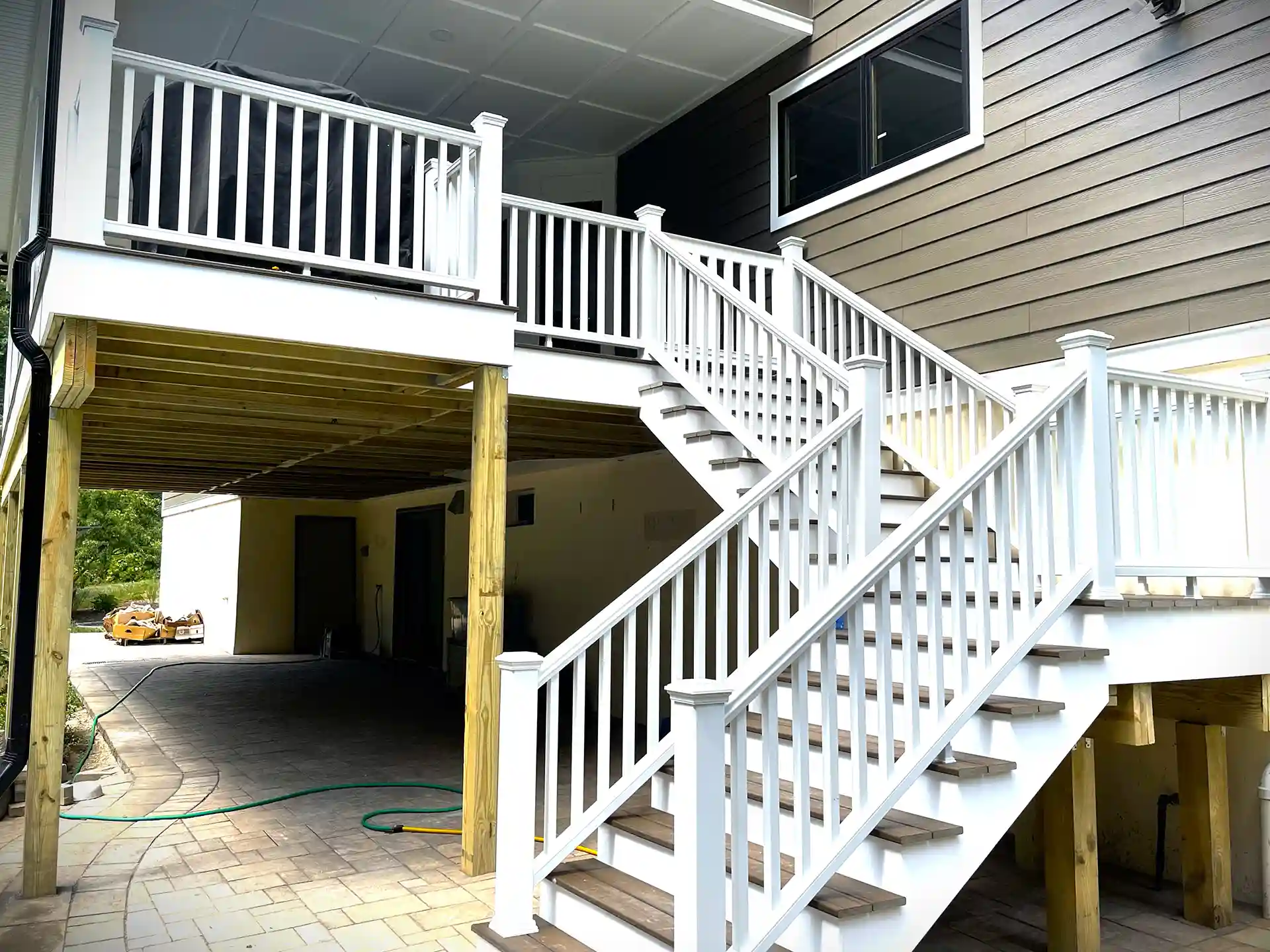 photo of an elevated composite deck with deck railing and steps and wood deck framing