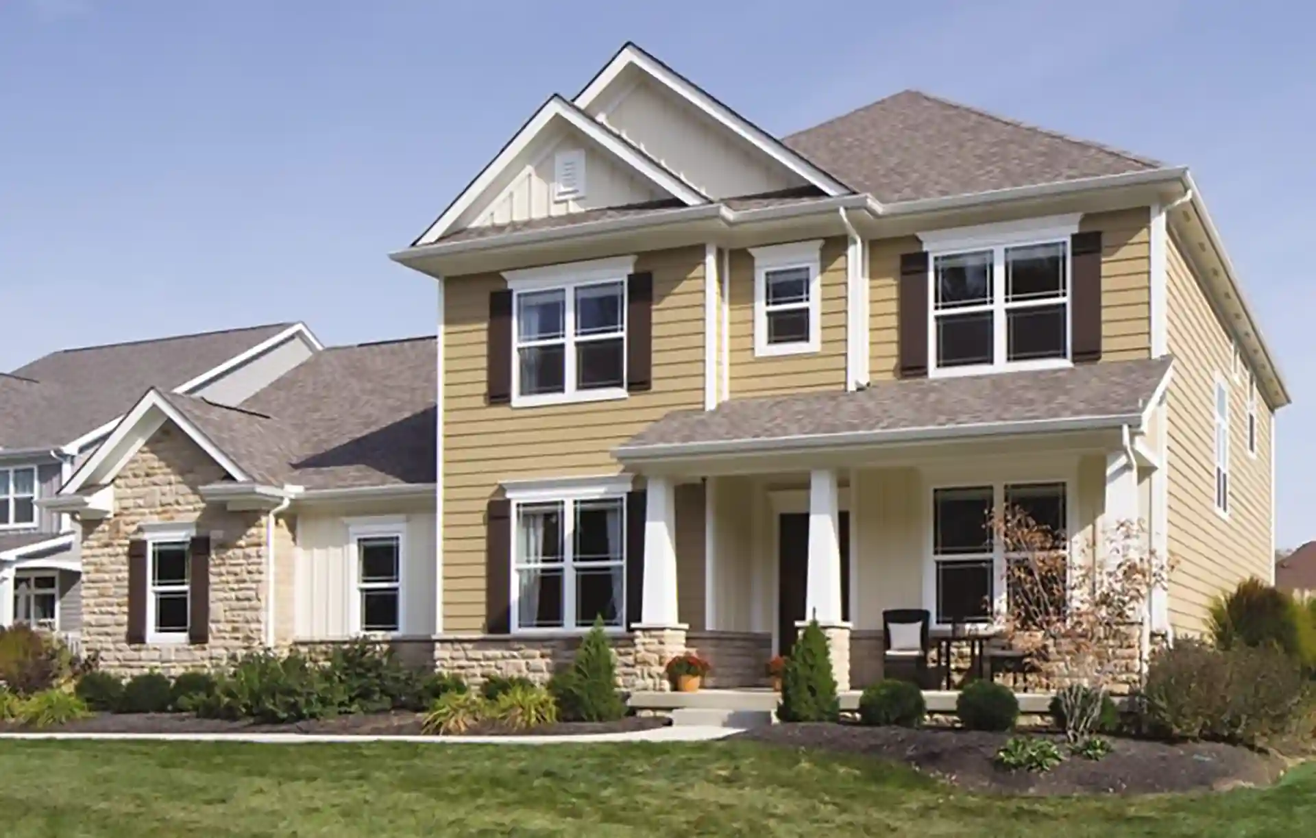 Two-story suburban home with a covered front porch and landscaped yard. 